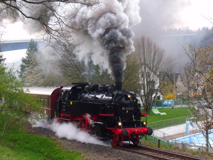 86 333 (nun wieder als 86 1333 beschriftet im DR-Standard) mit dem Zug 62277 von Schwarzenberg nach Annaberg-Buchholz, in der großen Schleife und Steigung um den Ort Markersbach herum, direkt gegenüber am Schwimmbad (wie man sieht), um 9:35h am 29.04.2017