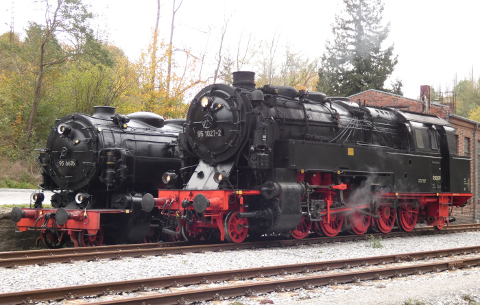 95 027  neben der hier (kalt) ausgestellten „Tierklasse“-Lok 99 6676 vor dem Lokschuppen im ehemaligen alten Abstellbahnhof Rübeland, um 14:37h am 21.10.2023