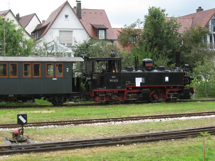 99 633 noch kalt und teilweise ohne Treibstangen ausgestellt im Bahnhofsbereich von Ochsenhausen, mit angeklebter / plakatierter Absicht und Hoffnung, die Lok nach kompletter Aufarbeitung wieder in Betrieb zu setzen, um 13:30h am 09.08.2007 fotografiert