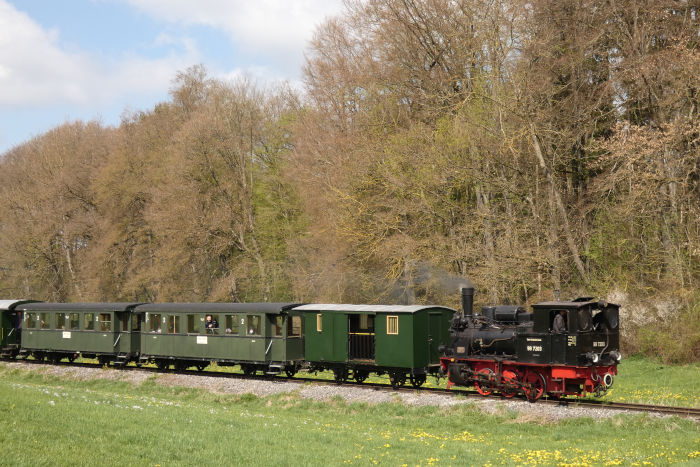 99 7203 Tv mit dem inzwischen komplett grünen und schöner ästetisch aussehenden Oppinger Zug kommt am Waldrand am oberen Duital zurück nach Amstetten gefahren, um 11:20h am 01.05.2022