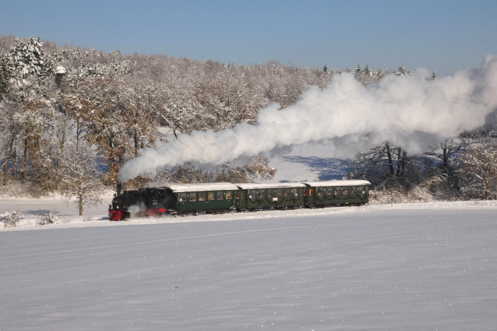 99 7203 noch mal mit dem ersten Nikolauszug des Tages in den schneebedeckten Feldern am oberen Duital, um 13:01h am 03.12.2023