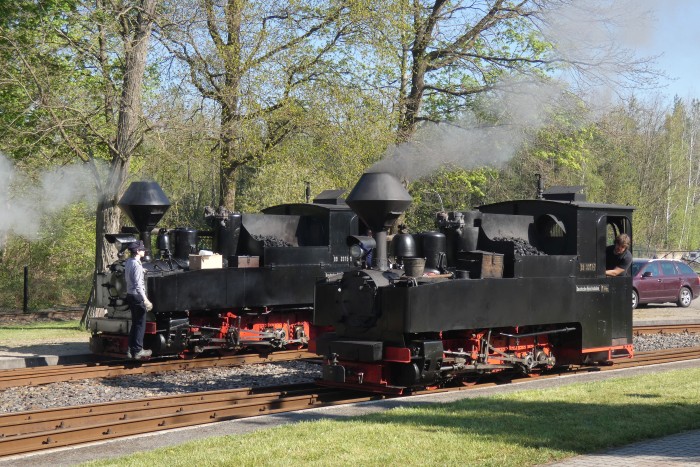 99 3315 kommt nun ebenfalls vorgefahren, um vor den Zug Richtung Kromlau gekuppelt zu werden, begegnet dabei der 99 3317, die gerade am vordersten Bahnsteiggleis an den Zug nach Muskau heran rollt, um 9:44h am 20.04.2025