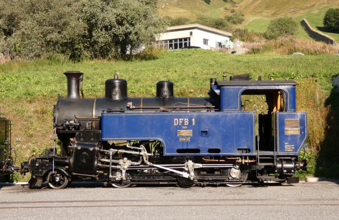 Die immer noch blaue HG3/4 Lok 1 DFB ausgestellt neben der Dampfschneeschleuder und vor der neuen großen Wagenhalle in Realp, am 12.08.2022
