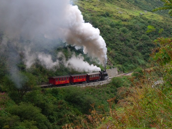 FO 4 mit dem zweiten Zug des Tages von Realp Richtung Furka hoch (-Gletsch), am Berghang des Furkareuss-Tales oberhalb der Wilerbrücke, um etwa 11:23h am 24.08.2014