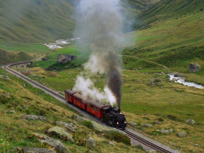 BFD 9 mit dem nachmittäglichen Zug Realp-Gletsch im oberen Furkareusstal hinter dem Steinstafelviadukt, um 14:52h am 15.08.2015