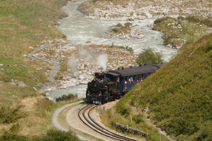 Lok FO 4 mit Zug Nr.157 in den Kurven im Reuss-Tal hinter Bahnhof Tiefenbach und vor dem Steinstafel-Viadukt, um 14:48h am 11.08.2022