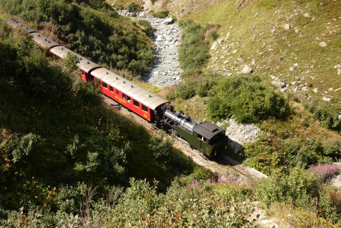 Lok 704 Tv vor dem Zug Nr.154 Oberwald→Realp abwärts fahrend unterhalb vom Alt-Senntumstafel-Tunnel II, um 15:44h am 12.08.2022