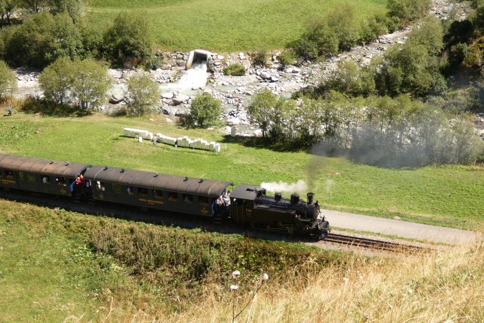 FO 4 mit Zug 157 zwischen Realp und den Wilerbrücken am Anfang der Zahnschiene von oben fotografiert, um 14:26h am 13.08.2022