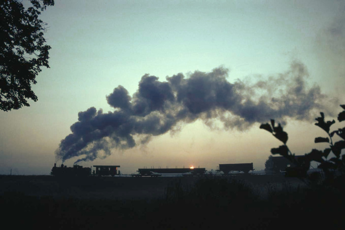 399 mit Güterzug in der Schleife bei Weitra früh morgens  bei/nach Sonnenaufgang, im Juli 1981